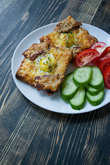 Grilled sandwich with egg, vegetables and bacon on a dark wooden background. Tasty breakfast.