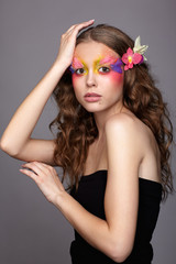 Portrait of teen girl with orchid flower in wavy hair.