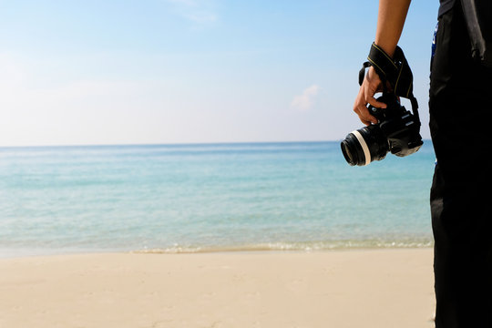 Photographer with camera Traveling backpacker of sea water and sand on the beach in tropical island with carefree and relaxing attitude - Travel Concept.