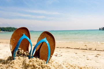 Beach sandals on the sandy sea, Summer concept with sandy beach. Vacation travel icon.