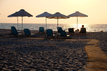 woman relaxing on the beach at sunset lights