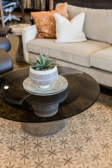 modern glass and metal coffee table, grey couch, pattered rug