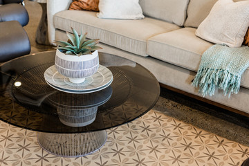 modern glass and metal coffee table, grey couch, pattered rug