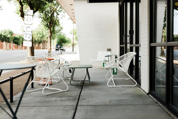 Modern white metal patio furniture with orange and green tables