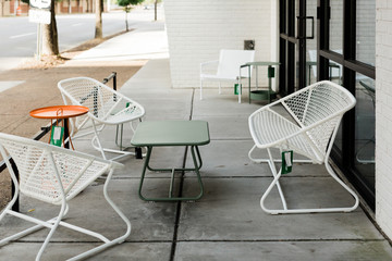 Modern white metal patio furniture with orange and green tables