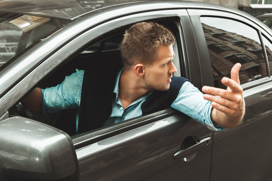 Young Handsome Man Looks Angry Having Argument With Other Drivers Sitting In His Car