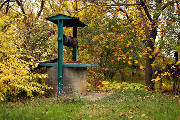 Well in the village, among yellow autumn leaves.