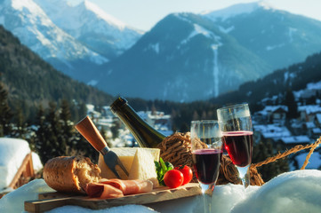 Traditional Italian food outdoor in sunny winter day. Romantic alpine picnic in Madonna Di...