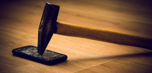 The hammer breaks the screen of the smartphone. A way to relieve stress