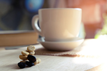 Relaxing moments , Cup of coffee and a book on wooden table in nature background, color of vintage tone and soft focus, winter morning concept.