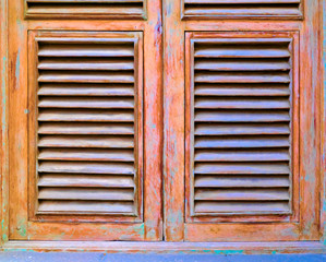 Louvered window shutters in timber, candy color pastel paint and warnish vintage finish.