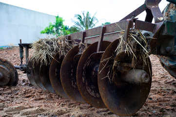 Closeup disk harrows on the back of tractor. Dirty steel blades of tractor.