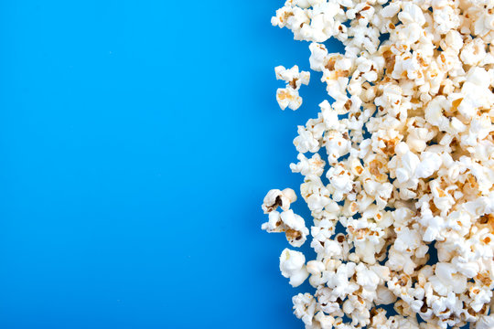 Tasty salted popcorn isolated on blue background. Copy space for text