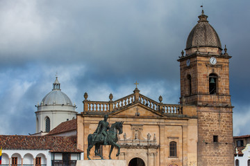 Historic equestrian monument to the Liberator Simon Bolivar with the Basilica of St. James the Apostle on background at the Bolivar Square in the Colombian city of Tunja