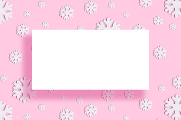 Christmas round frame made of white decor holiday snowflakes on pink background. Flat lay, top view