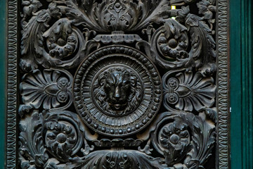 Door knocker with lion. wooden door lion lock. Decorative door handle in form of bronze lion head on old wooden entrance door