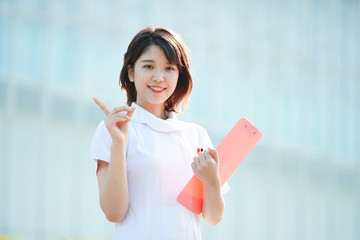 人差し指を立てる白衣の女性