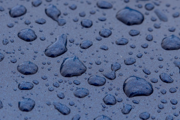 rain drops on a blue metal surface closeup