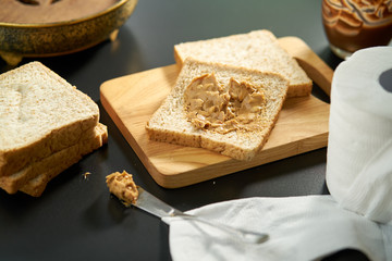 Peanut butter with bread on cutting board