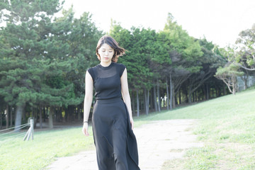 Fototapeta premium 海沿いの公園を歩く若い女性