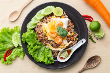 Fried brown rice with shrimp and fried egg in Thai. Prepared and served in a work, Low calories, Healthy food, Top view.