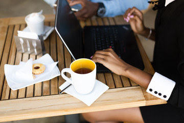 Black  African American coworkers doing digital teamwork arround a coffee cup