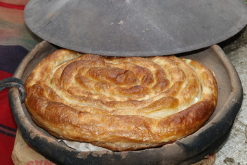 Freshly baked homemade bread arranged in traditional Bulgarian textiles. Image of some tasty Home-made bakery products. Fresh bread,brown, wheat, sliced, round, product, bagel, delicious, baking.