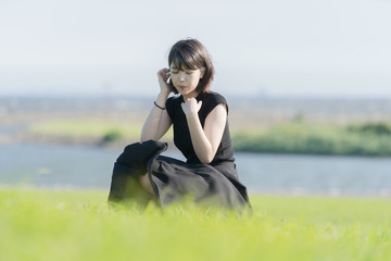 海沿いの公園で座る若い女性