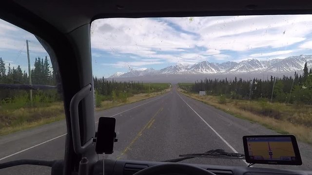 POV driving commercial truck on the Alaska highway with a dirty windshield.