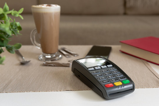 Payment machine and smartphone on the table in cafe, nfc payment concept