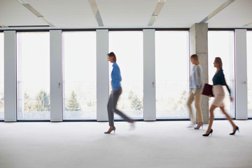 Business people walking in office corridor