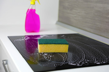 Cleaning the induction hob with a sponge.