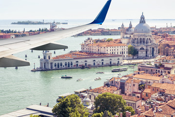 Plane flies above Venice, Italy. View of city from airplane window. Concept of flight, vacation and summer air travel. © scaliger
