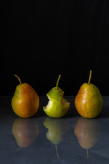 Fototapeta na wymiar Three ripe pears are reflected in the table