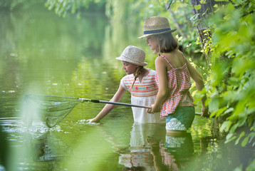 Fototapeta na wymiar Young girls fishing in Lake using butterfly fishing net