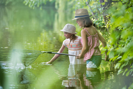 Young girls fishing in Lake using butterfly fishing net