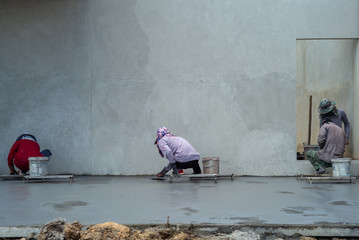 Back portrait group of workers use trowel for flooring the cement suface