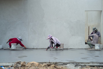 Back portrait group of workers use trowel for flooring the cement suface