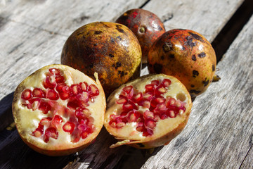 Pomegranate fruit (Punica granatum) split open to reveal the clusters of juicy  seeds on the inside