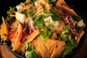 macro view on finely decorated cheese and greens salad over black
