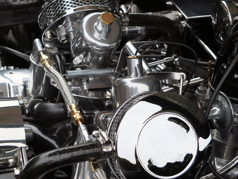 a shiny polished chome and steel vintage sports car engine