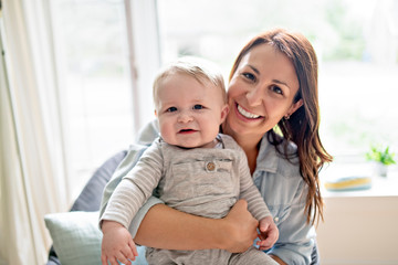 Mother with her baby on a chair at living room