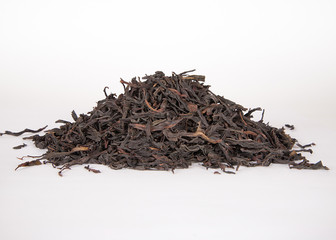 Black dry tea leaves isolated on white background