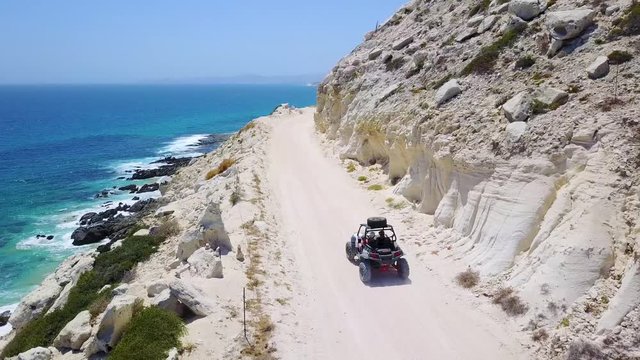 Good aerial of an ATV speeding on a dirt road near Cabo, Baja Mexico.
