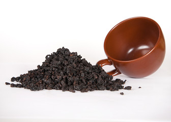 A heap of Chinese black loose leaf tea with brown cup