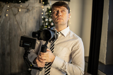 A beautiful young photographer on a colored background holds a camera and a candy bar, takes off well