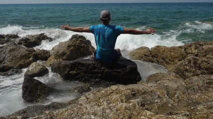 Man looking at sea and showing freedom while sea storm.