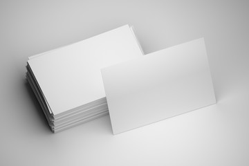 Blank mock up of stack of white business cards with one standing card on white background. 3d illustration.