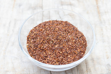Loose tea rooibos superior in a glass cup on a wooden background
