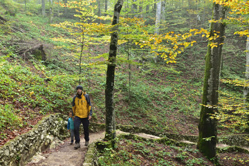 Obraz na płótnie Canvas Boy and his father traveling together, hiking in Plitvice National Park, Croatia, in the fall